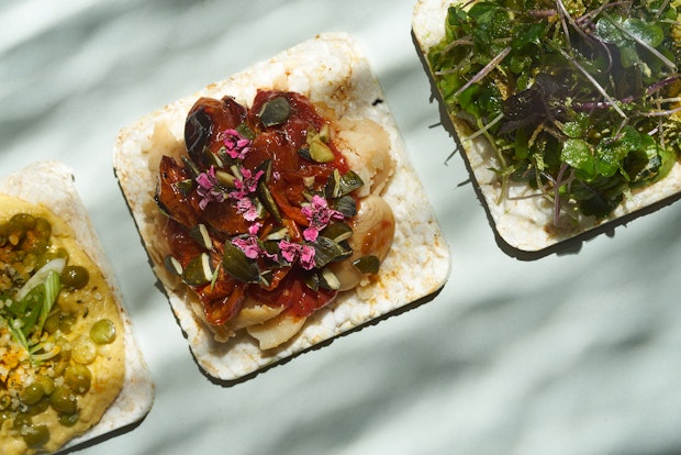 rice cracker topped with beans and roasted cherry tomatoes