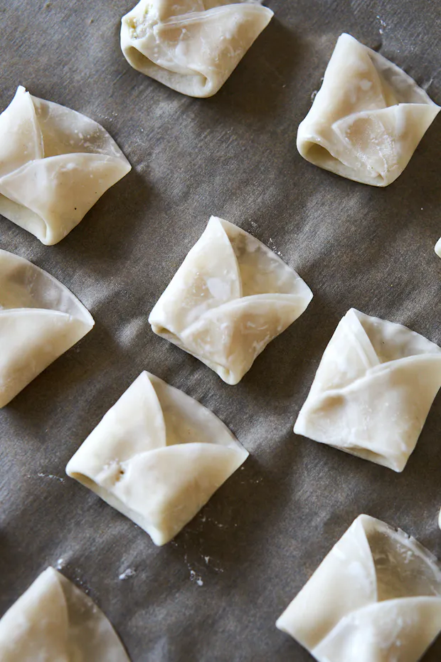 Folding ricotta dumplings and arranging on baking sheet