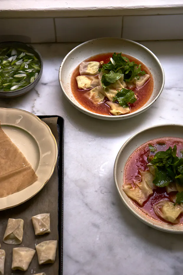 Preparing ricotta dumplings in a tomato broth in a kitchen