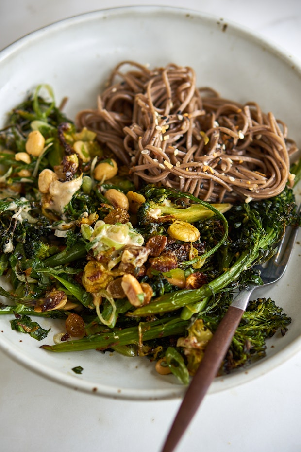 roasted broccoli along with noodles and fork on a table for dinner