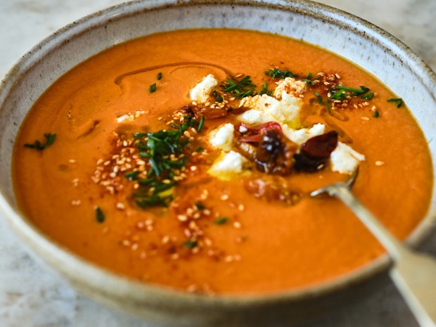 roasted tomato soup in a bowl goat cheese and chives as toppings