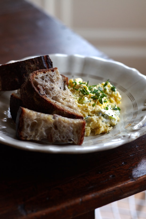 Scrambled eggs made with cream cheese on a plate with sourdough toast