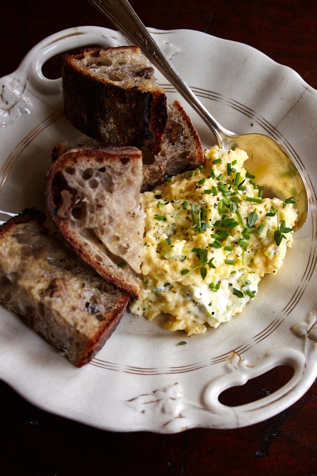 Scrambled eggs made with cream cheese on a plate with sourdough toast