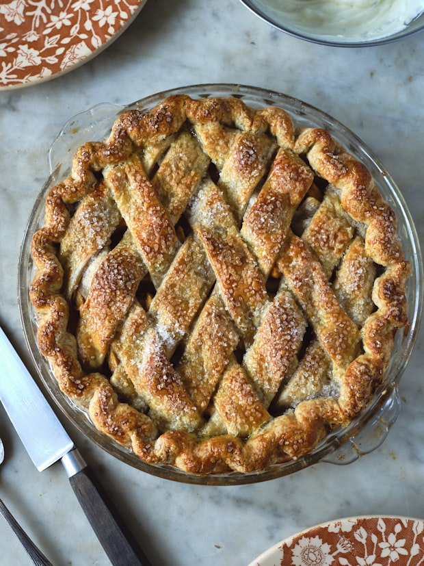 an apple pie with lattice crust in a glass pie dish ready to be sliced