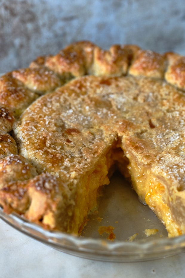 shaker lemon pie with a wedge cut out in a glass pie dish