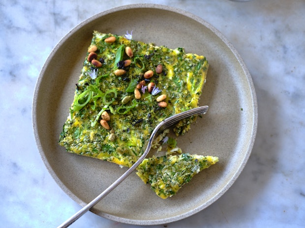 a square piece of sheetpan frittata on a plate with a fork