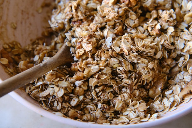 Oat dan bahan -bahan lain dikombinasikan dalam mangkuk untuk membuat granola