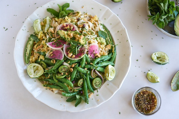 spring roll salad arranged on a large plate with dressing on the side