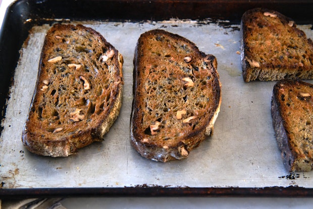 homemade sourdough bread, sliced and toasted on a baking sheet