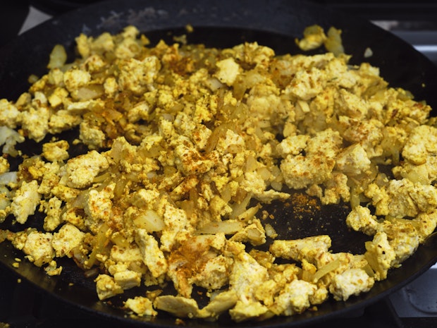 Cooking tofu scrambled eggs ingredients in a pan