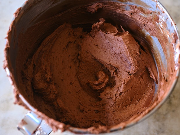 chocolate frosting in a metal mixing bowl