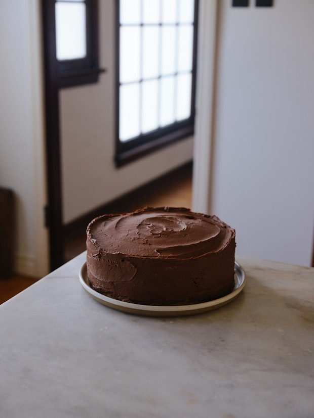 chocolate frosted yellow cake on a counter in a kitchen