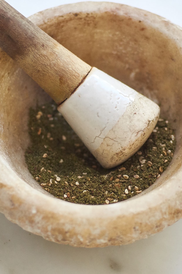 za'atar in a mortar with a pestle to blend